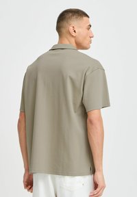 Meeste lühikeste käistega polo särk helesalajases rohelises. Omab vabalt sihvakat lõiget, sileda puuvillase materjali ja klassikalist krae.
