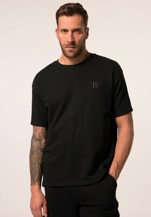 Camiseta negra de manga corta con cuello redondo, que presenta un logo sutil en el lado izquierdo del pecho. Fabricada en un tejido suave y ligero.
