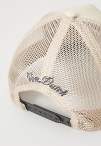 Light beige cap with mesh back, featuring a plastic strap and black "Von Dutch" embroidery on the side. The front is solid with a button on top.