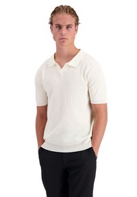 Lichtcrème polo shirt met korte mouwen, voorzien van een gestructureerd oppervlak, met een contrasterende witte kraag en geribde zoom.