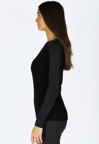 Langsleeve top in zwart en donkergrijs stof, met een getailleerd ontwerp en een gladde textuur, weergegeven in zijprofiel tegen een witte achtergrond.
