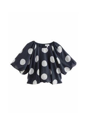 Marineblå bluse med overdimensionerede puffærmer, prydet med store hvide polka dots og en rund halsudskæring. Fremstillet af letvægts, struktureret stof.