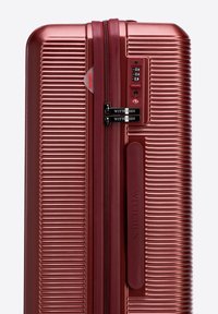 Rose gold hard-shell suitcase with ribbed texture, dual zippers, and TSA lock. Brand name "WITTCHEN" embossed on the side.