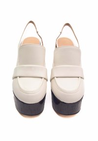 Scarpe platform bianche in pelle con finitura liscia, punta arrotondata, cinturino largo sulla parte anteriore e base testurizzata simile al legno nera.