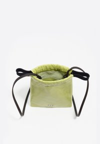 Bolso de cuero verde de tamaño mediano con superficie texturizada, cierre de cordón y correas ajustables de color marrón oscuro. Se observa un logotipo de marca destacado.