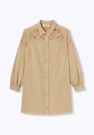 Robe chemise beige avec des détails en dentelle brodée sur les épaules, fermeture à boutons sur le devant, manches longues avec des poignets élastiques et une poche sur la poitrine. Tissu léger.