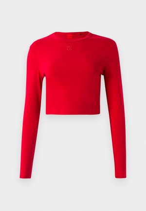 Top croppat roșu cu mâneci lungi, guler rotund și mic logo embosat "HUGO" centrat sub guler, pe un fundal simplu.