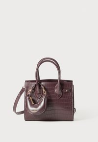 Sac à main en crocodile marron foncé avec doubles poignées et pochette plus petite attachée avec fermeture éclair dorée et logo sur fond uni.