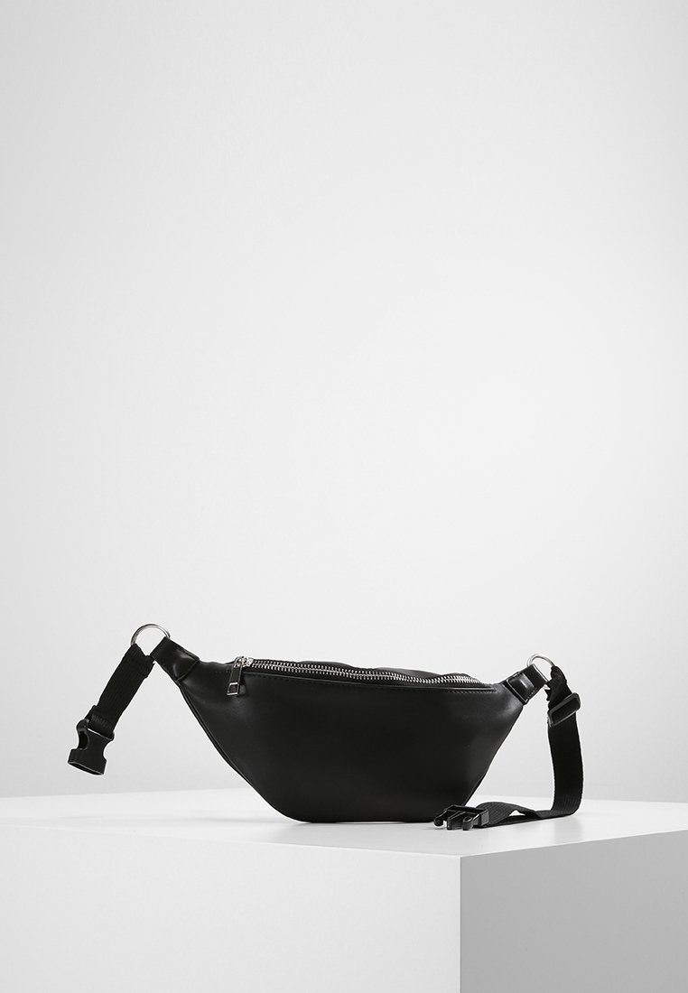 Czarna skórzana torebka na ramię o trójkątnym kształcie, z zamkiem błyskawicznym i regulowanym paskiem. Gładka faktura i minimalistyczny design.