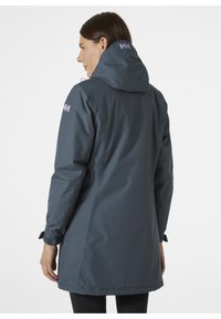 Voděodolná šedá parka s kapucí, nastavitelnými manžetami a logem na zádech. Hladká textura a délka do boků.