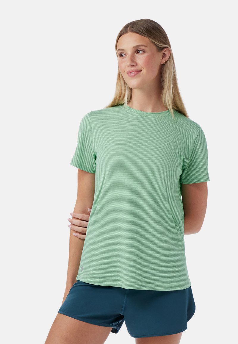 T-shirt de sport texturé à manches courtes, vert clair, avec col rond et coupe décontractée, associé à un short bleu marine.
