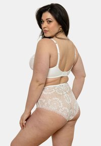 Ensemble de lingerie en dentelle blanche comprenant un soutien-gorge avec des bretelles ajustables et une culotte taille haute avec des détails floraux et une doublure lisse.