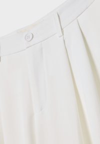 Witte geplooide broeken met een gladde textuur. Heeft een platte voorkant, zijzakken en een enkele knopen sluiting bij de taille.