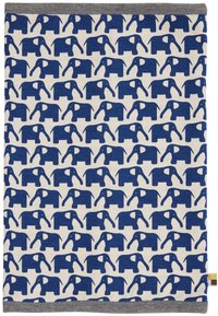 Coperta in cotone caratterizzata da un motivo ripetitivo di elefanti blu scuro su uno sfondo crema, con un bordo grigio e un'etichetta colorata.