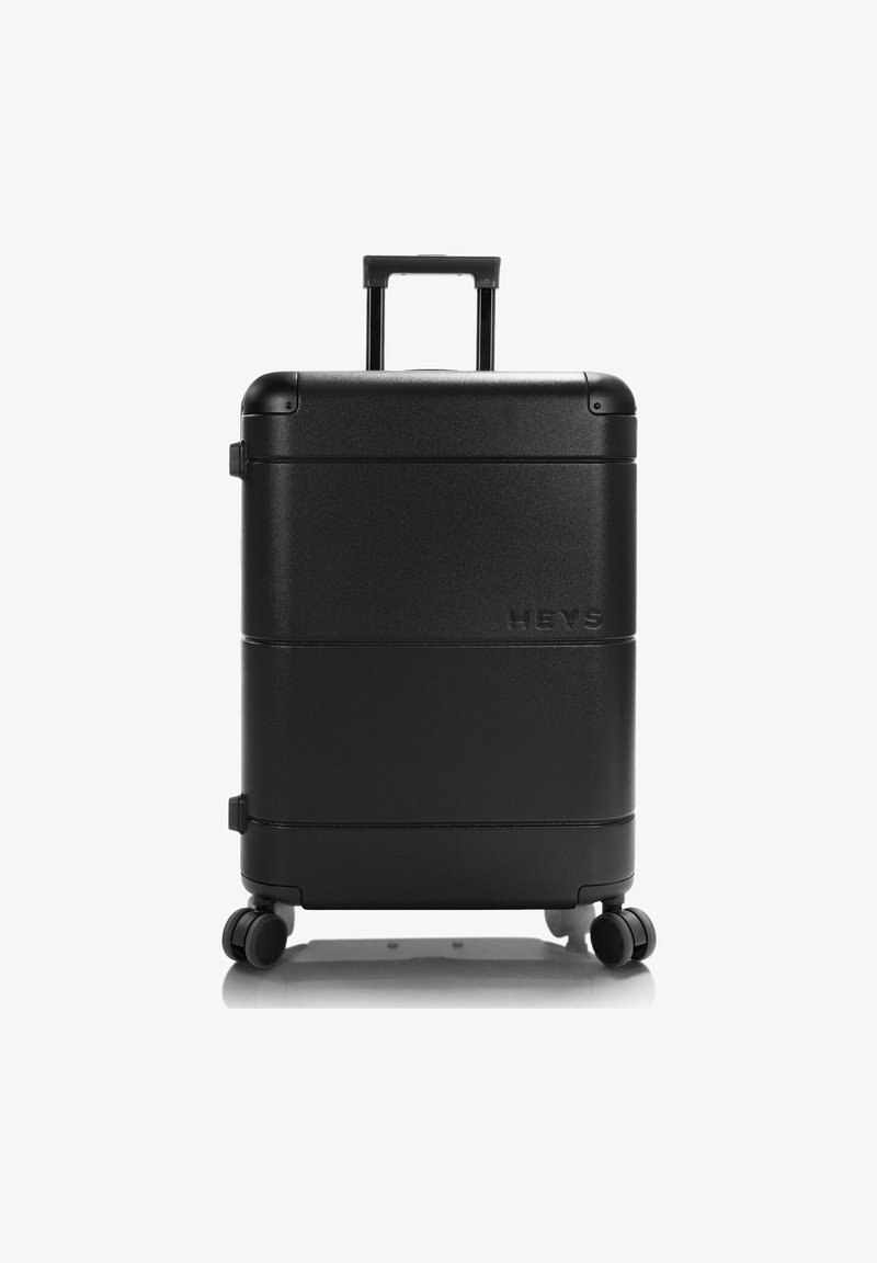 Black hard-shell suitcase with a textured finish, featuring a retractable handle, four spinner wheels, and embossed brand logo.
