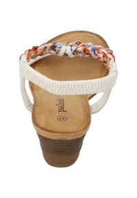 Sandale blanche avec une sangle tressée multicolore, semelle intérieure rembourrée et un talon en bois brun. Caractérisée par une semelle texturée et antidérapante.