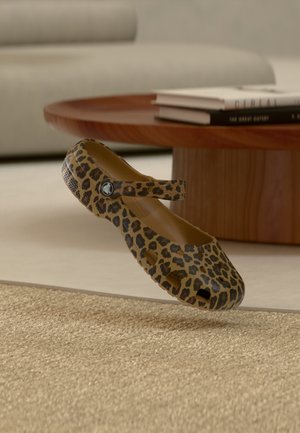 Leopard print flat shoe with a rounded toe, a strap across the instep, and ventilation holes. Made of flexible material with a smooth texture.