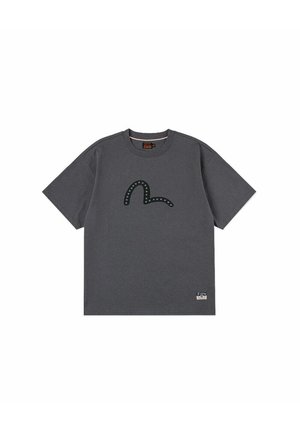 T-shirt grigio scuro a maniche corte con scollo rotondo, con un design curvo borchiato sul petto e una piccola patch del marchio vicino all'orlo inferiore.