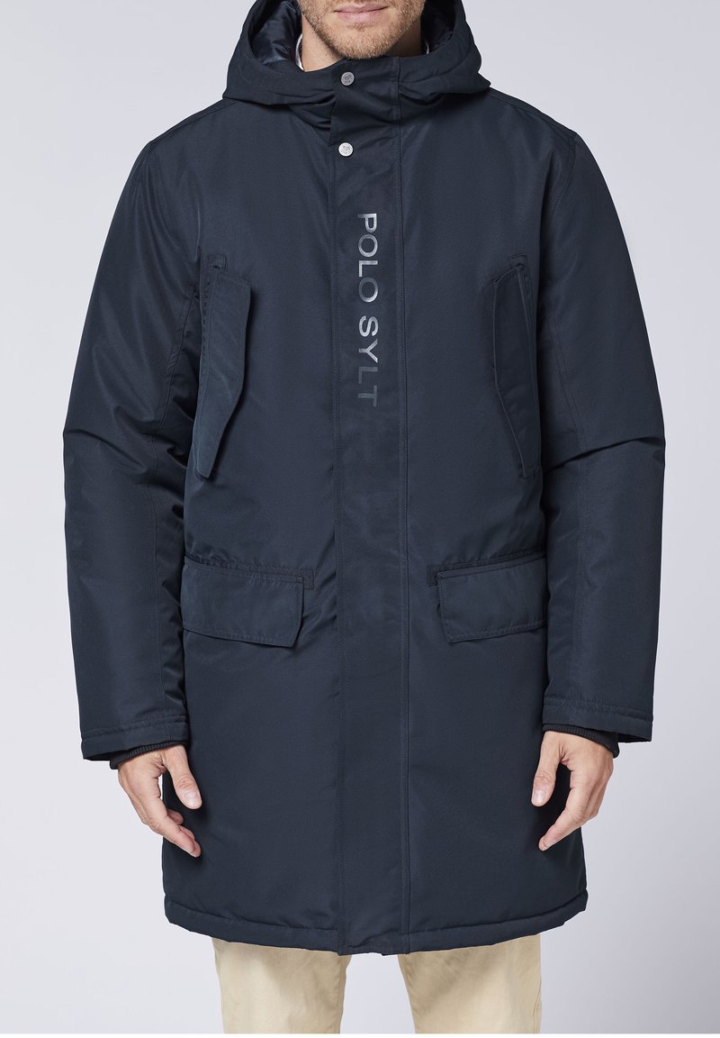 Navy blue parka jacket featuring a zip and snap closure, two front pockets, and "POLO SYLT" logo in white along the front. Textured fabric.