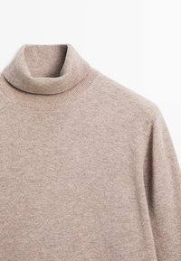 Tan turtleneck sweater made of soft knit fabric; features a ribbed neckline and texture with a smooth finish.