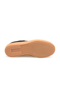 Chaussure en daim noir avec semelle en caoutchouc ; couleur beige clair ; motif de semelle texturé pour l'adhérence ; design minimaliste, bout arrondi.
