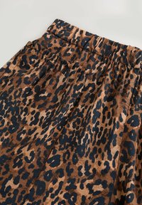 Suknja s leopard uzorkom u smeđoj i crnoj boji, s elastičnom trakom u struku, glatkom teksturom i nabranima za dodatni volumen.