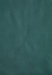 Teal stof med en glat tekstur, der viser et diskret diagonalt mønster. Materialet virker slidstærkt og velafsluttet.