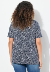 Top a maniche corte blu navy con motivo floreale bianco, vestibilità morbida, tessuto morbido e orlo arrotondato. Adatto per un look casual.