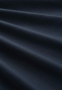Tissu bleu marine foncé avec une texture lisse, présentant des plis subtils. Le matériau semble doux avec un léger éclat et sans motifs visibles.