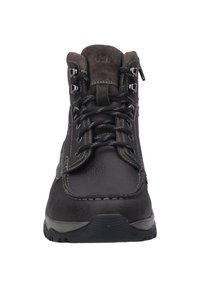Stivale da trekking in pelle marrone con lacci neri, occhielli metallici e collarino imbottito. Suola in gomma e zip laterale per un facile accesso.