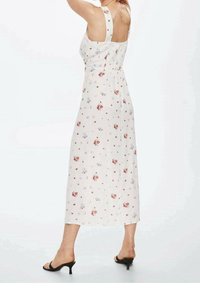 Robe midi florale en tissu crème avec des fleurs rouges et violettes, bretelles ajustables et dos smocké, présentant une silhouette fluide.