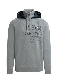 Gray knitted pullover with a high collar and a navy hood. Features button closure and printed text details on the front. Textured fabric.