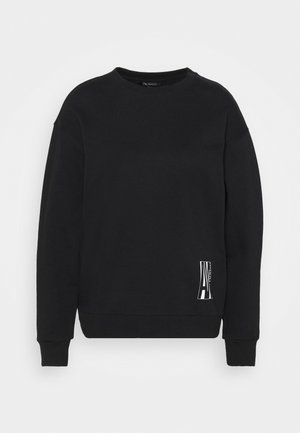 Sudadera negra de manga larga con cuello redondo, puños y dobladillo acanalados, con un pequeño logo vertical blanco cerca del lado derecho inferior.