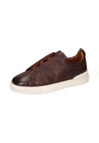 Zapatilla de cuero marrón con superficie texturizada, forma alargada y suela de goma beige. Presenta cordones ocultos y una pequeña pestaña en el talón.