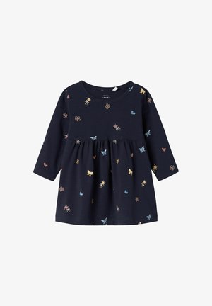 Vestido de marina hecho de una tela suave con mangas largas. Presenta una cintura fruncida y estampados de flores y corazones multicolores.