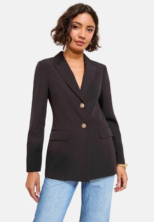 Schwarzer Blazer aus glattem Stoff mit tiefem V-Ausschnitt, zwei vorderen Taschen und zwei goldenen Knöpfen zum Schließen. Taillierte Passform, lange Ärmel.