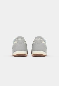 Sivi nubuk tenesici s laganim plavim naglaskom i krem bešavnom sredinom, s gumiranim potplatom i ušivenim Reebok logom na peti.