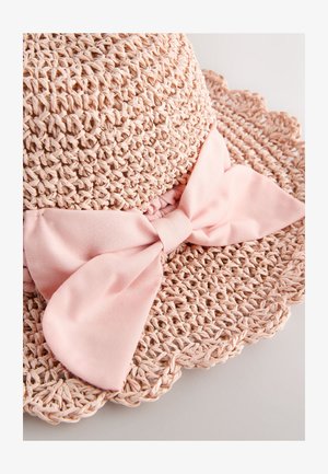 Stråhatt i mjuk rosa med bred brätte, med en strukturerad vävd design och en stor rosa tygrosett vid basen som accent.