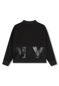 Chaqueta negra con media cremallera que presenta un panel de malla texturizada con la letra "NY" en la parte posterior, cuello y puños acanalados para un ajuste ceñido.