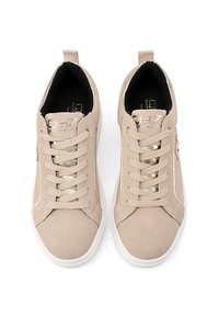 Scarpe da ginnastica beige in suede con finitura texturizzata, dotate di lacci piatti, accenti dorati e suola in gomma bianca. Nessun marchio visibile all'esterno.