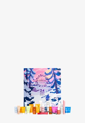 Calendrier de l'Avent avec une boîte illustrée colorée représentant des arbres enneigés et une maison. Contient 24 petits tubes de produits de beauté de différentes couleurs.