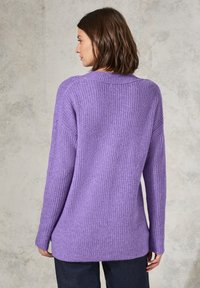 Pull en tricot violet avec une texture côtelée, des manches longues et une coupe décontractée. Présente un design à épaules tombantes subtil et un col large.