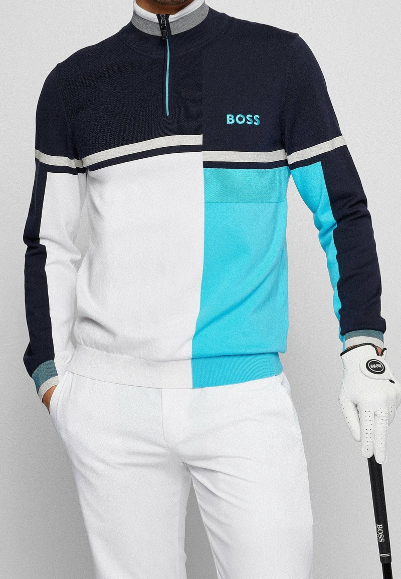 Marinblå, vit och turkos zip-up golfpullover med en färgblockdesign, som har horisontella ränder och "BOSS"-logotyp i blått.