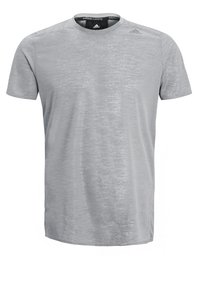 Camiseta de manga corta gris claro hecha de tejido transpirable, con una textura sutil y cuello redondo. Logo de Adidas en negro en la parte superior izquierda.