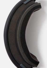 Almofada de espuma preta e cinza com um design curvo. Apresenta uma superfície texturizada e bordas suaves, integrada a uma estrutura de plástico.