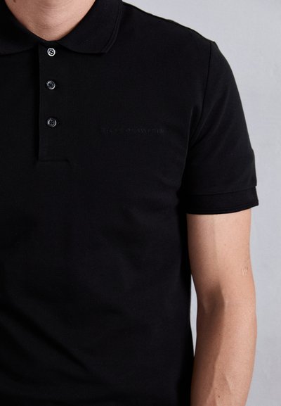Svart polo skjorte laget av teksturert bomull, med klassisk krage, tre knappeåpning og preget logo på brystet.