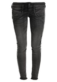 Vaqueros ajustados de mezclilla gris oscuro con detalles desgastados, cinco bolsillos y un ligero deshilachado en el dobladillo. Costuras detalladas en los laterales.