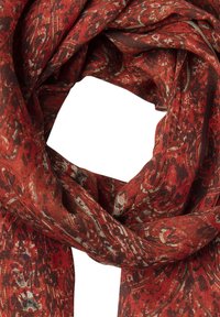 Sciarpa rossa con motivo floreale nelle tonalità di rosso, marrone e verde tenue, realizzata in tessuto leggero e testurizzato, disposta in forma circolare.