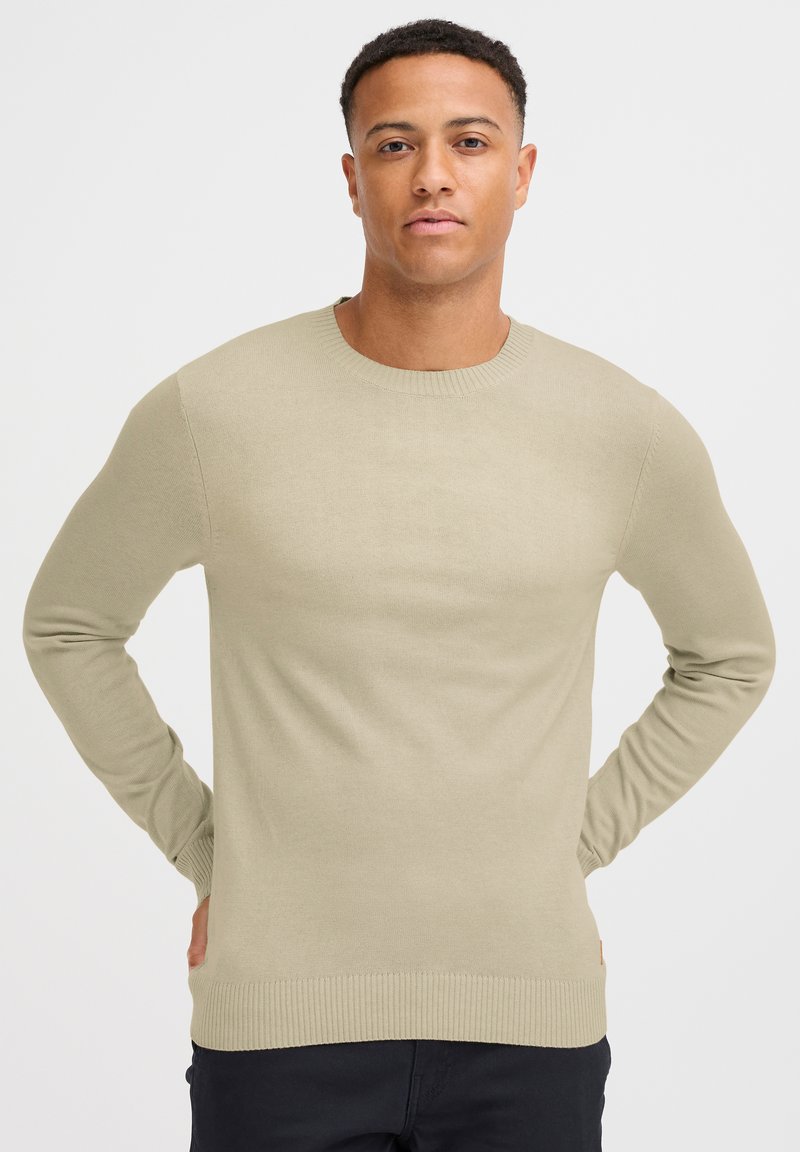 Hellgrüner Strickpullover mit Rundhalsausschnitt, langen Ärmeln und gerippten Abschlüssen. Glatte Textur mit figurbetontem Schnitt und ohne sichtbare Muster.