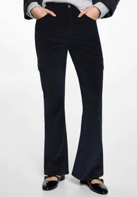 Námornícke kordové nohavice s rozšírenými nohavicami, prednými vreckami, zapínaním na gombík a zips a viditeľnými švami po stranách. Navrhnuté na voľný strih.